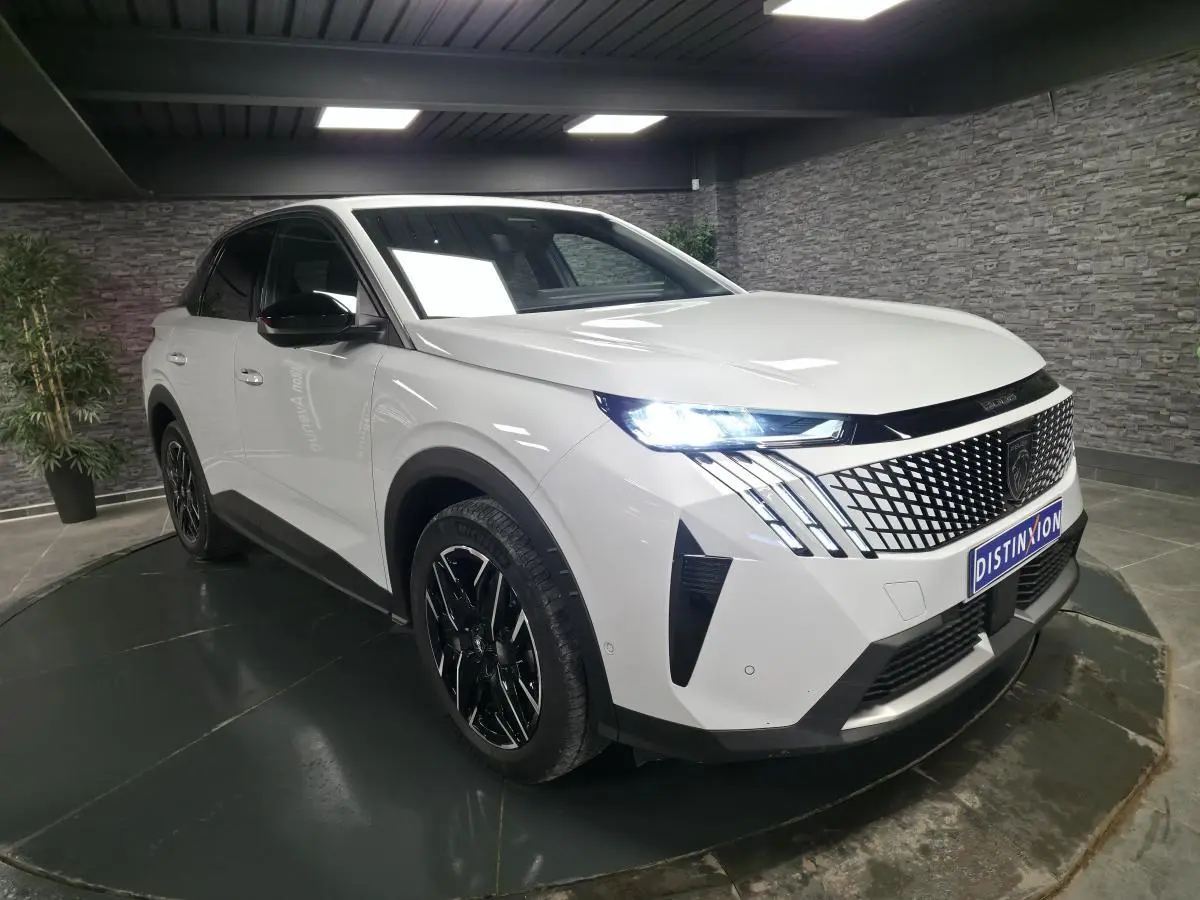 Peugeot 3008 blanc en 3/4 avant droit, avec calandre noire à motif géométrique et phares LED allumés.
