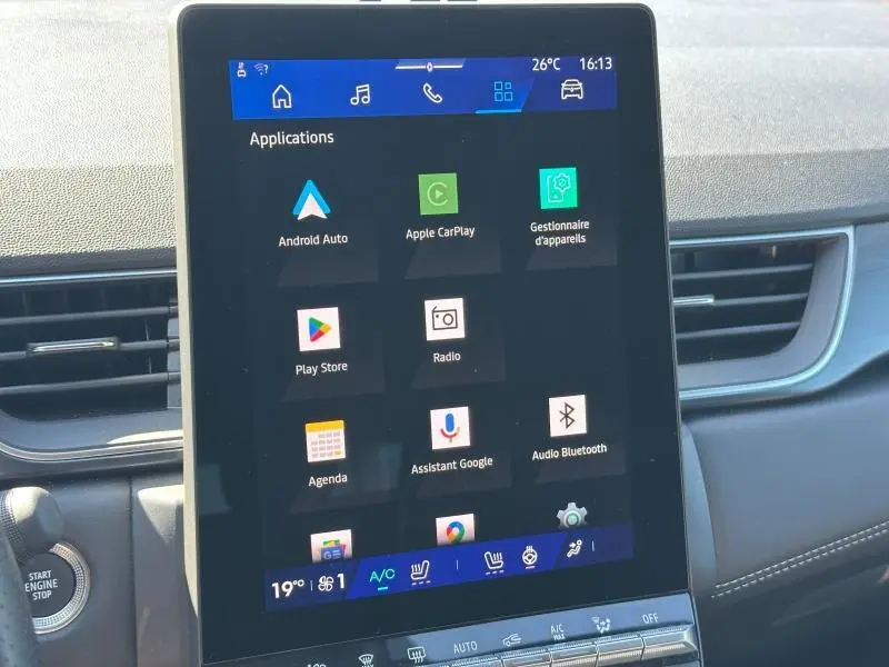 Écran tactile central affichant les applications multimédias dans l’habitacle d’une Renault Symbioz rouge, vue de face.