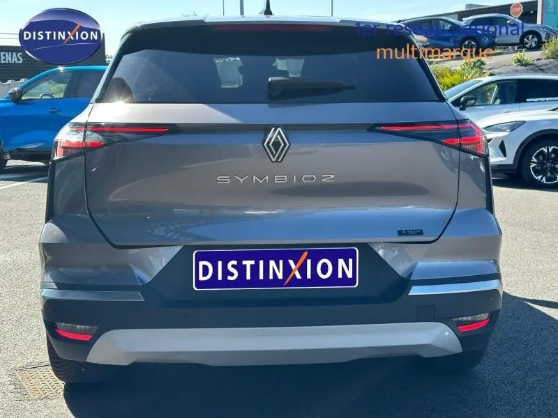 Vue arrière d'une Renault Symbioz grise avec feux arrière LED fins et logo central lumineux.