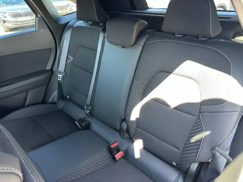 Vue intérieure de la banquette arrière noire du Renault Symbioz 2025 avec ceintures et appuie-têtes visibles.