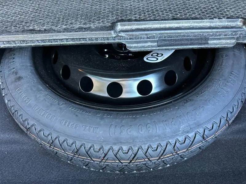 Gros plan sur la roue de secours noire dans le coffre d'une Renault Symbioz rouge 2025.