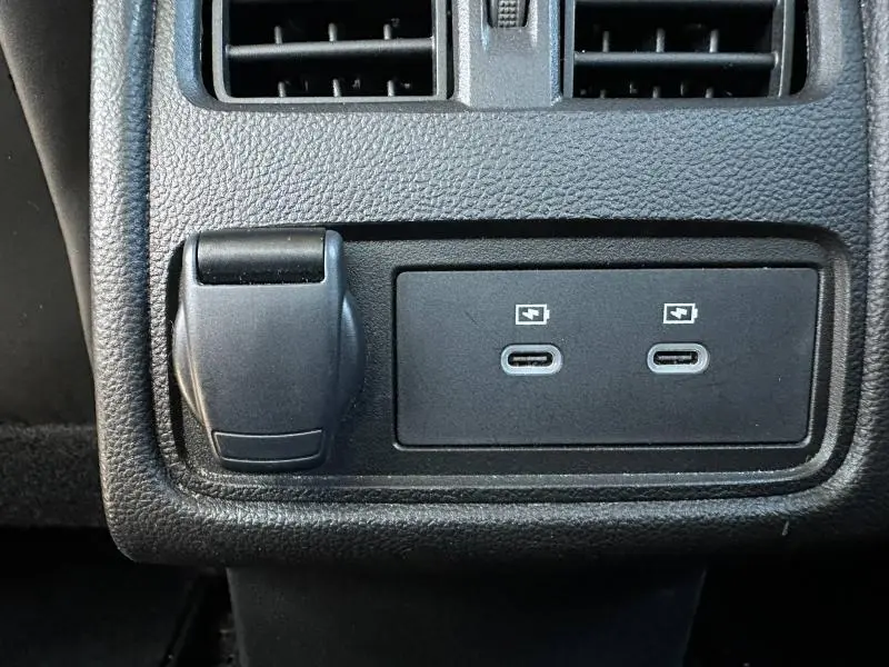 Gros plan sur les prises USB-C et prise 12V noires dans l'habitacle du Renault Symbioz rouge.