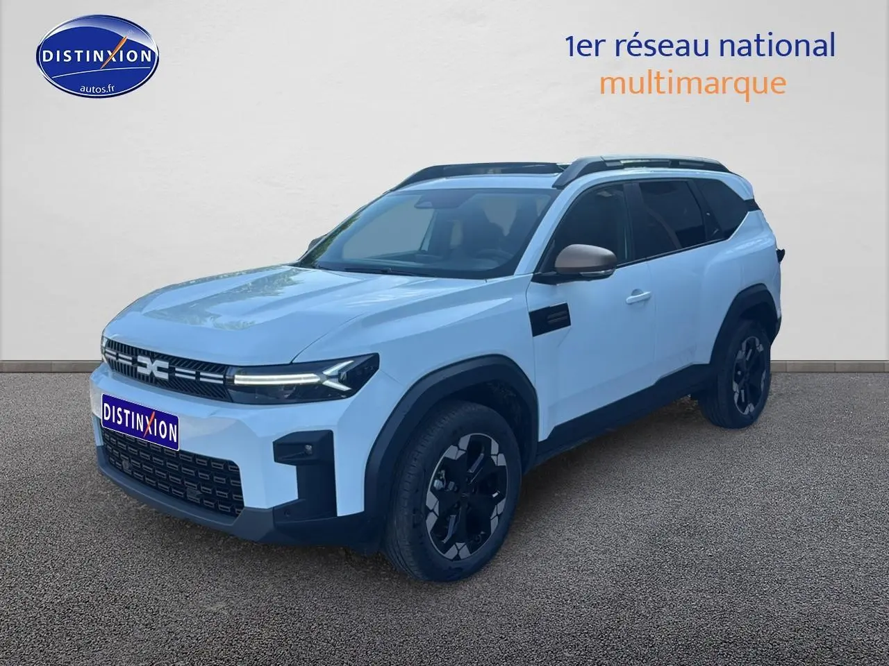 SUV Dacia Bigster blanc en 3/4 avant droit avec barres de toit et jantes noires distinctives.