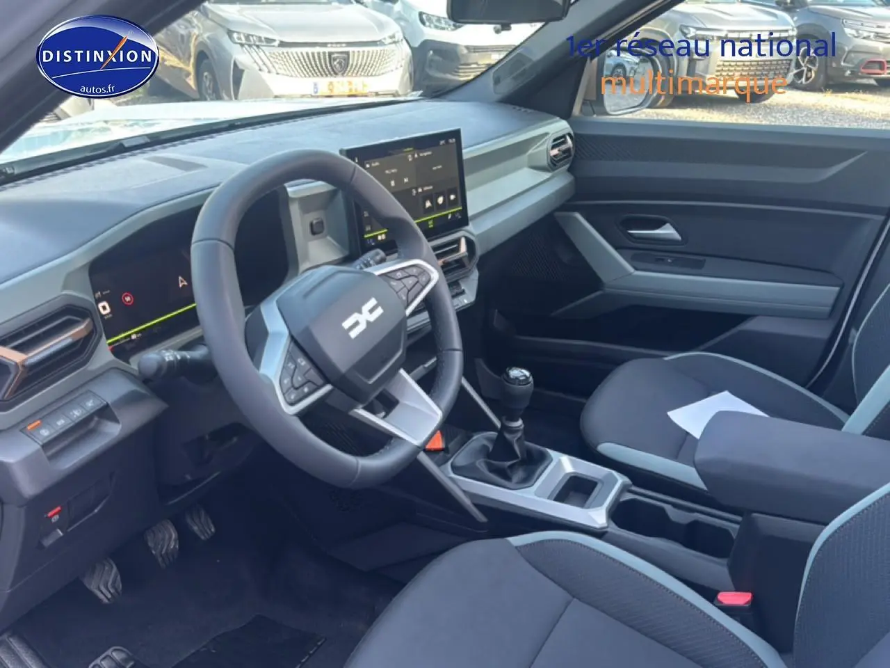 Vue intérieure côté conducteur du Dacia Bigster blanc 2026, volant multifonction et écran tactile central visibles.
