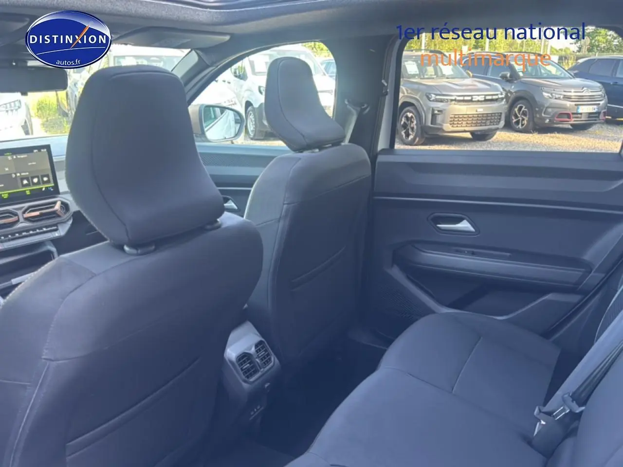 Vue intérieure arrière côté droit du Dacia Bigster 2026 avec sièges noirs et tablette tactile avant visible.