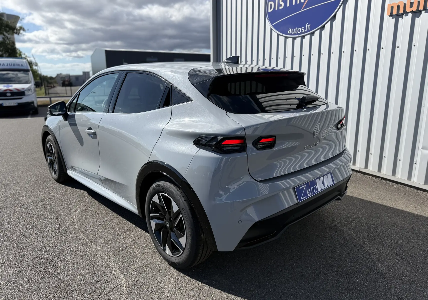 Renault Clio VI TCe 115 Techno gris Rafale vue 3/4 arrière droit, feux LED et jantes bi-ton visibles.