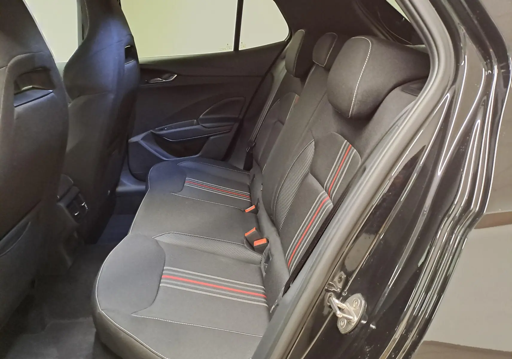 Vue côté droit des sièges arrière noirs avec surpiqûres rouges et grises d'une Skoda Fabia 2024 Monte-Carlo Noir Magic Nacré