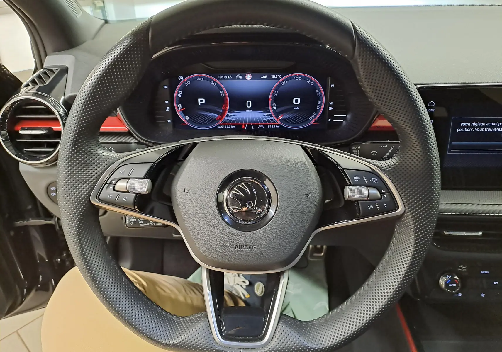 Vue centrée sur le volant perforé et le tableau de bord numérique d'une Skoda Fabia 1.5 TSI noir Magic Nacré 2024.