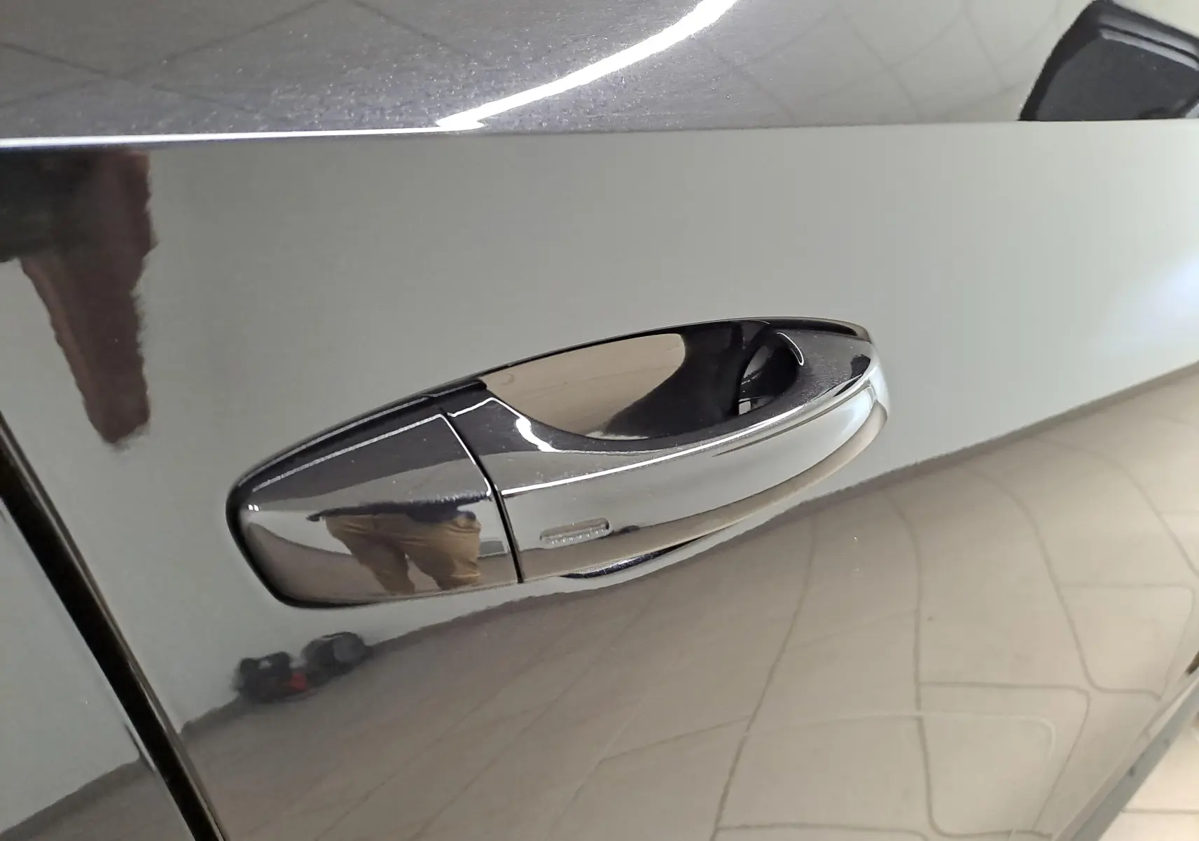 Poignée de porte chromée en gros plan sur la portière côté gauche d'une Skoda Fabia noire Magic Nacré 2024.