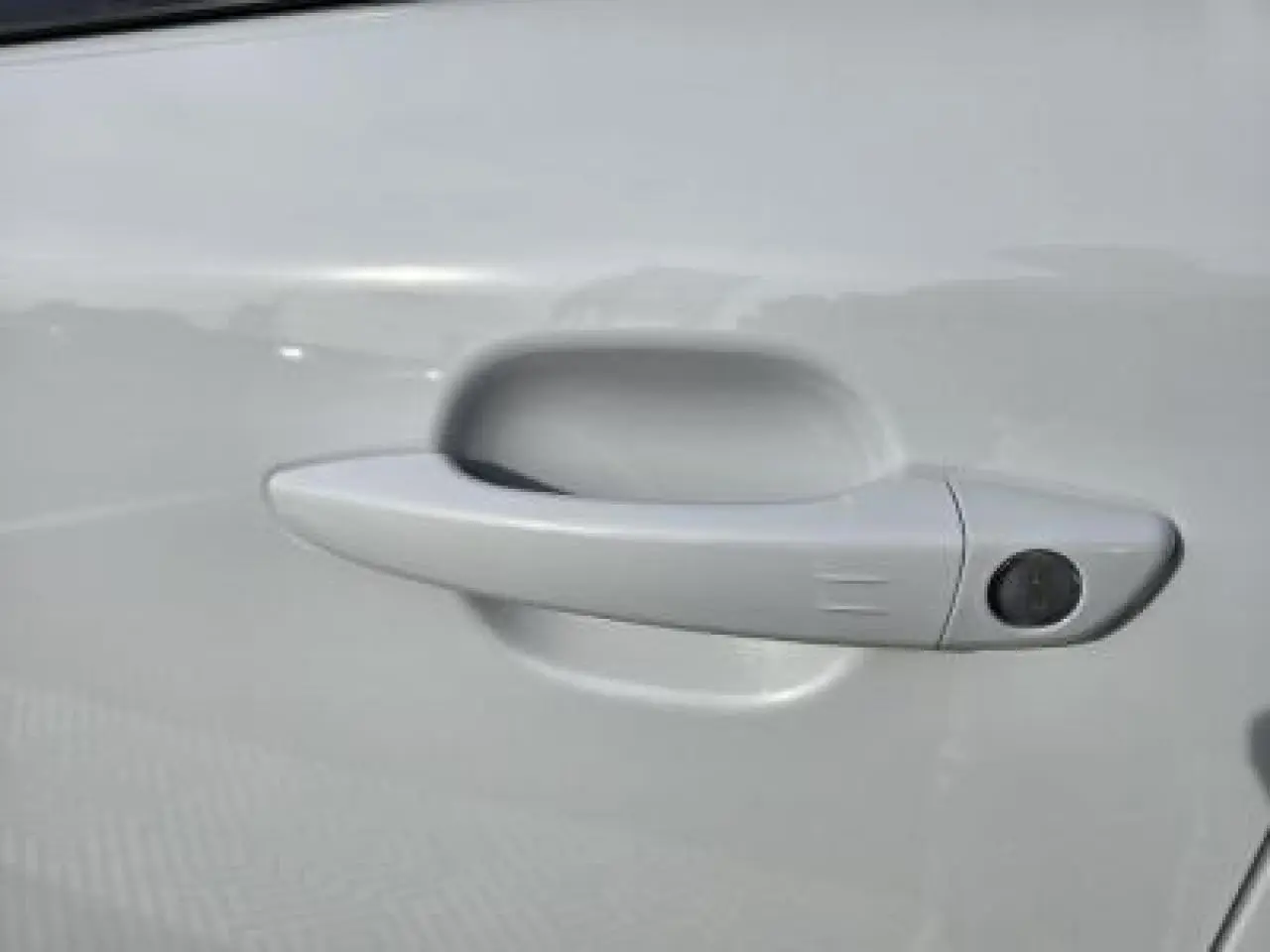 Poignée de porte blanche côté gauche du Peugeot 2008 hybride 2025 avec capteur d'ouverture intégré.