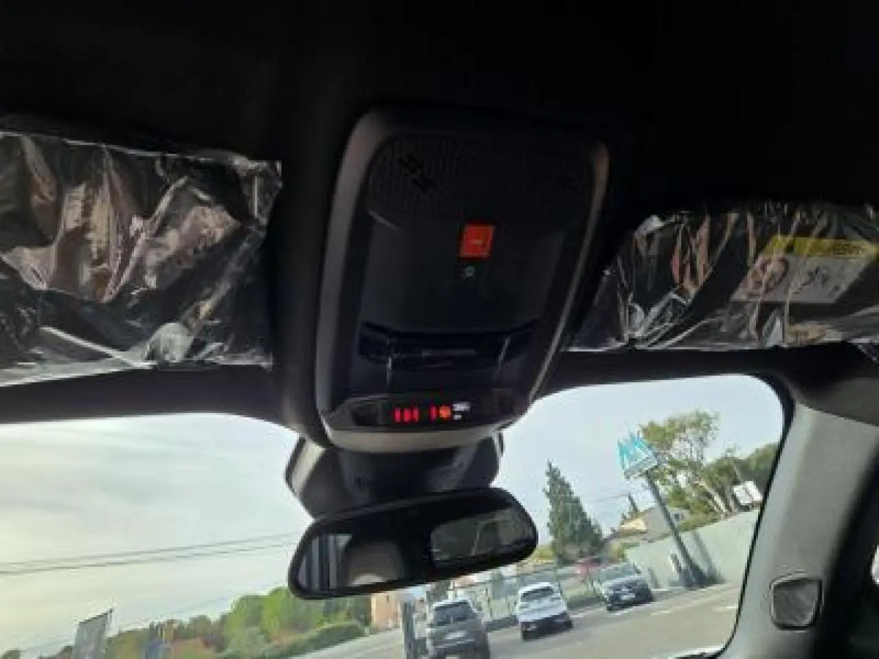 Vue intérieure du plafond avant du Peugeot 2008 blanc avec commandes d'éclairage et rétroviseur central visible