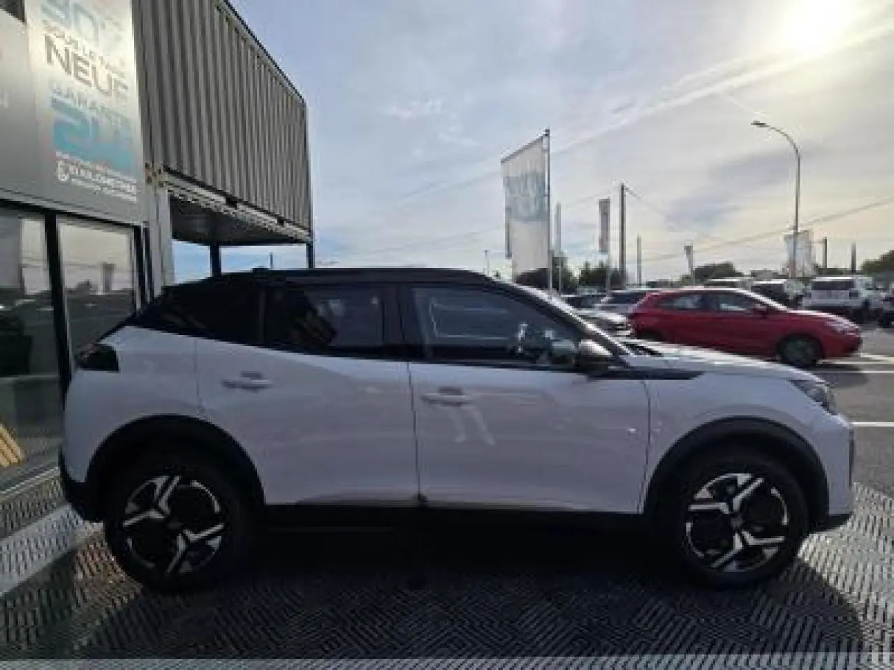 Profil droit du Peugeot 2008 hybride blanc Okenite avec toit noir et jantes alliage bi-ton 17 pouces.