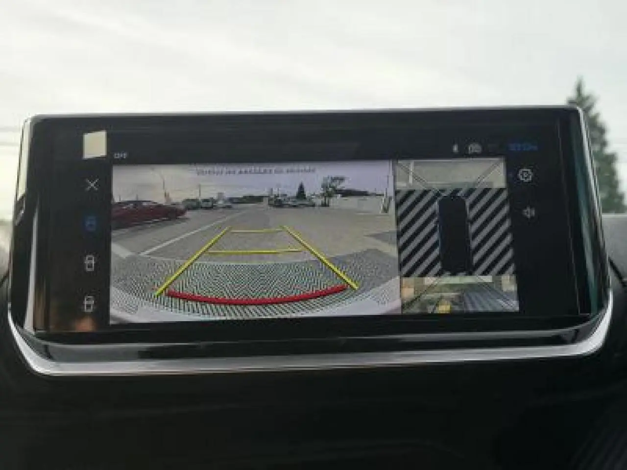 Écran tactile intérieur affichant la caméra 360° de recul du Peugeot 2008 blanc toit noir, vue arrière stationnement.