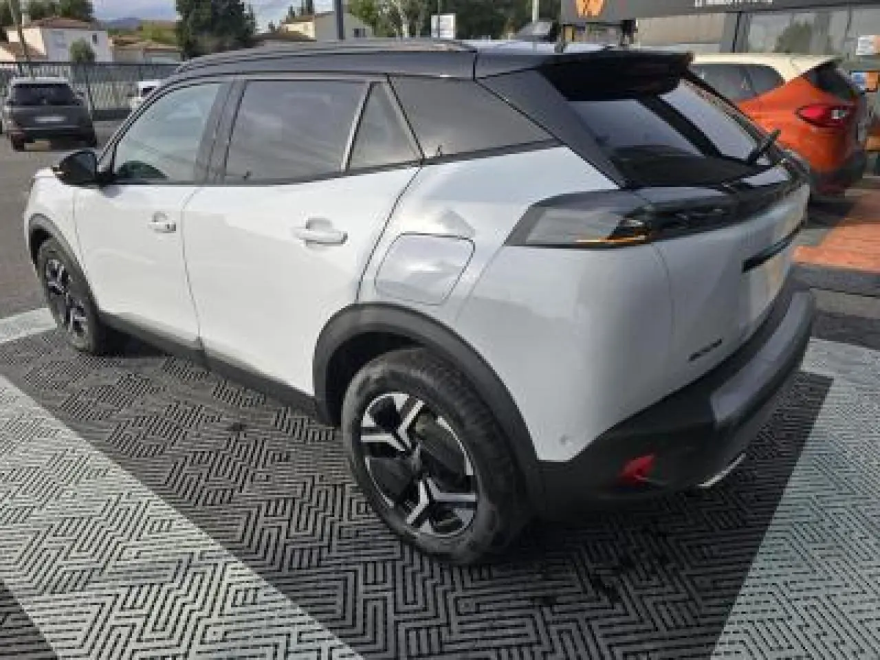 Vue 3/4 arrière droite du Peugeot 2008 blanc Okenite avec toit noir et jantes alliage bi-ton 17 pouces.