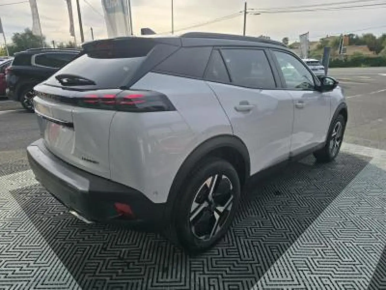 Vue 3/4 arrière droite du Peugeot 2008 blanc Okenite avec toit noir et jantes alliage bi-ton 17 pouces.