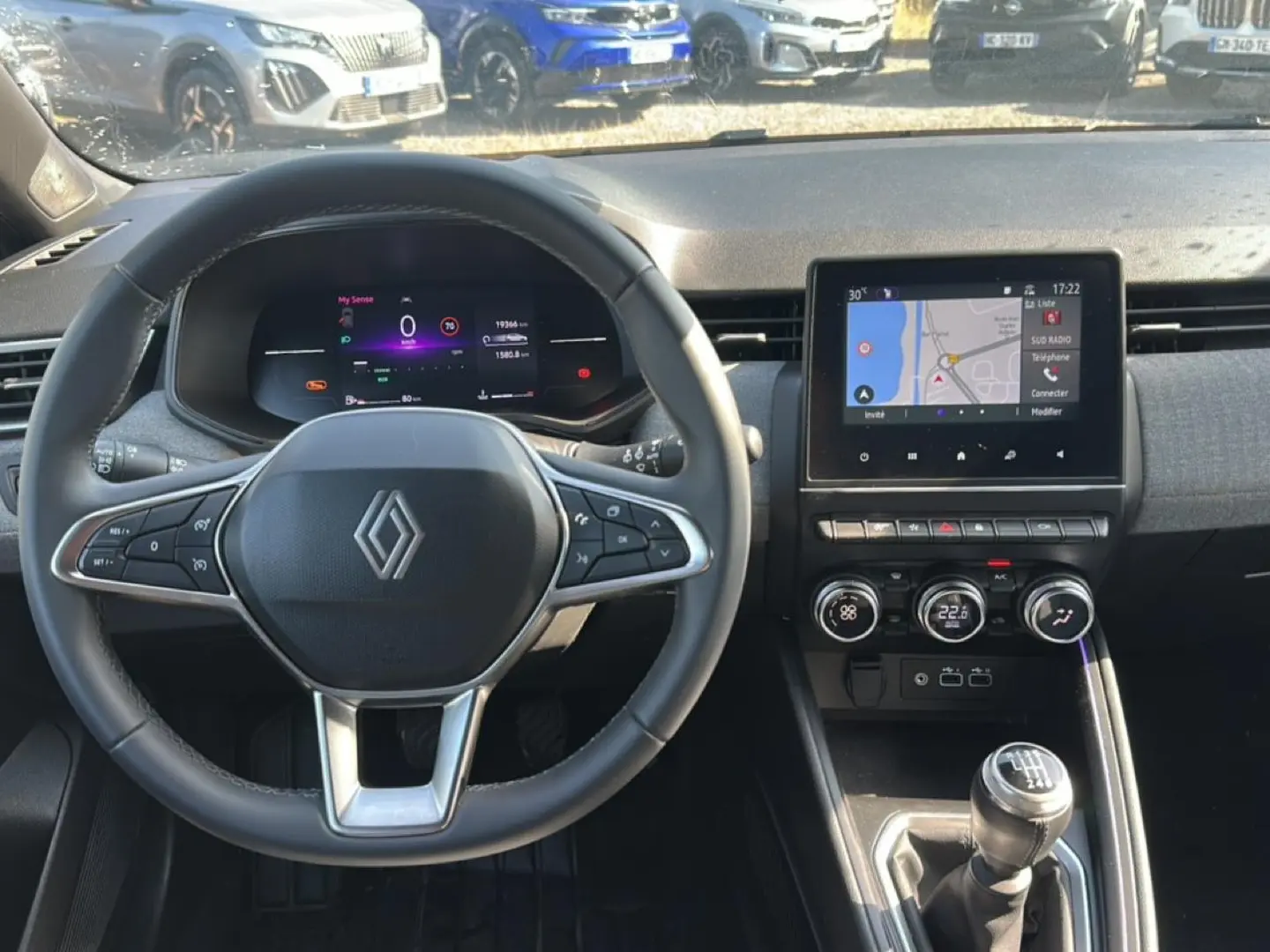 Vue intérieure centrée sur le volant et la console centrale tactile de la Renault Clio V gris schiste, boîte manuelle.