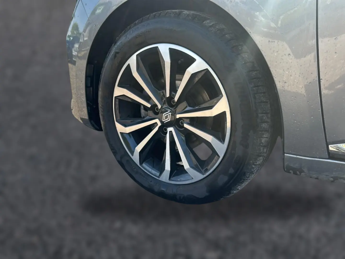 Gros plan sur la roue avant droite de la Renault Clio V gris schiste, mettant en valeur la jante alu au design moderne.