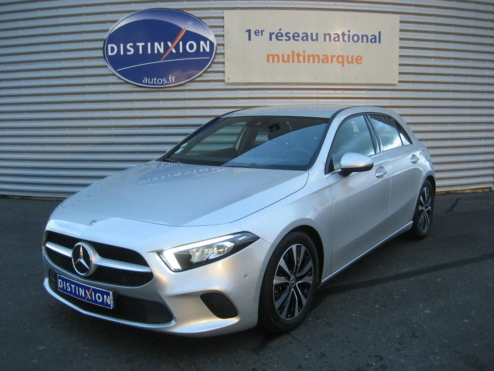 Mercedes Classe A180D gris vue 3/4 avant droit, avec calandre distinctive et jantes bi-ton.