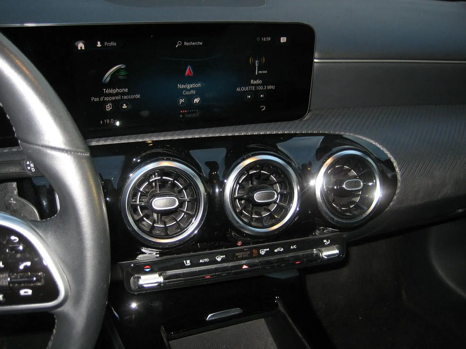Vue rapprochée de la console centrale de la Mercedes Classe A 180d 2021, avec écran tactile et aérateurs ronds chromés.