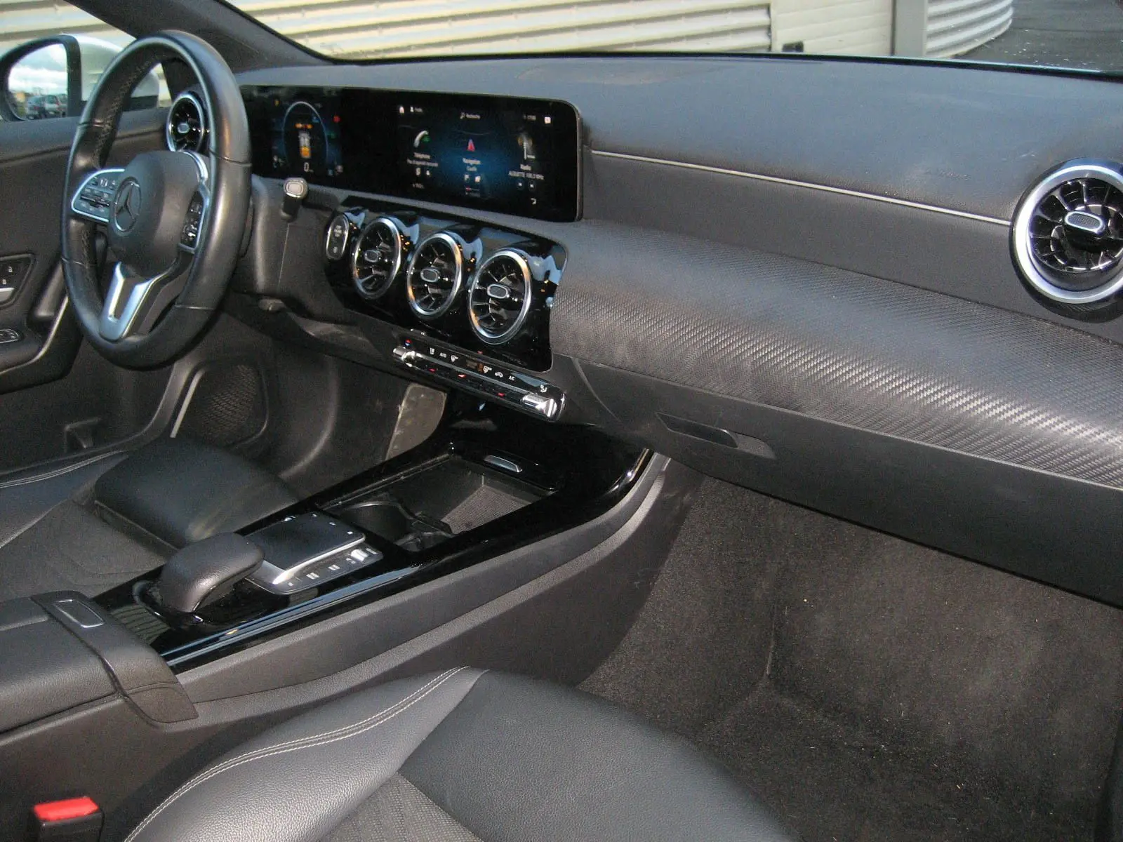 Intérieur de la Mercedes Classe A 180d Business Line 2021, vue de profil gauche sur le tableau de bord et la console centrale noire.