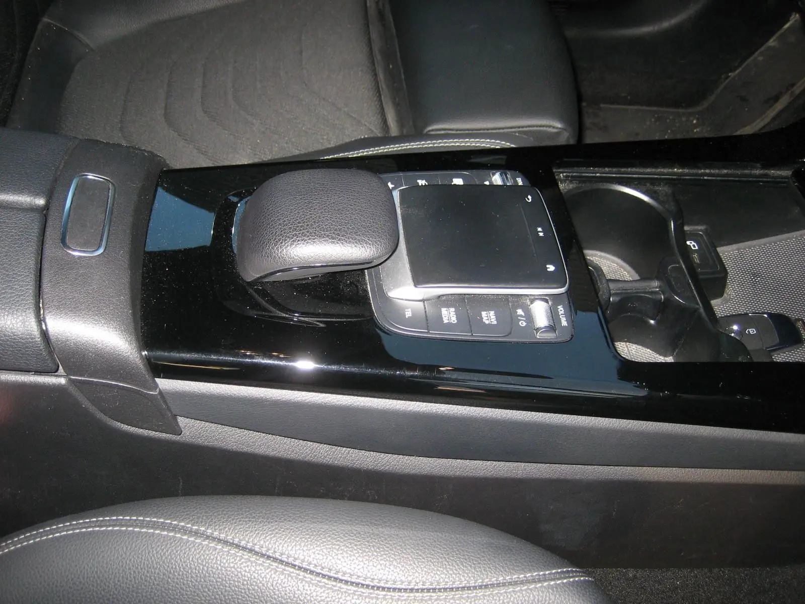 Vue rapprochée de la console centrale noire brillante avec levier de vitesse et commandes tactiles du Mercedes Classe A gris 2021.
