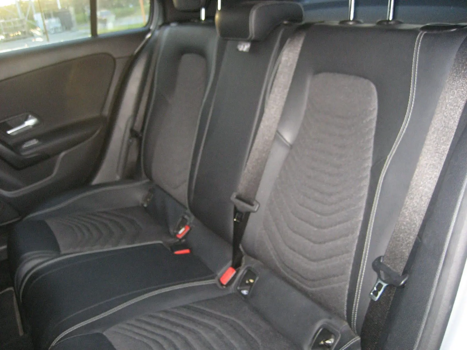 Vue intérieure des sièges arrière en tissu noir avec ceinture de sécurité dans une Mercedes Classe A gris 2021.