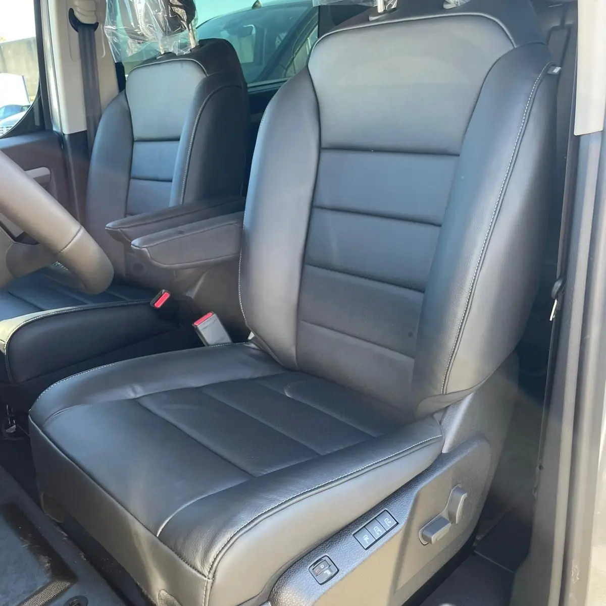 Vue intérieure côté conducteur du siège avant en cuir noir du Citroën Jumpy Cabine Approfondie 2026 avec commandes électriques.