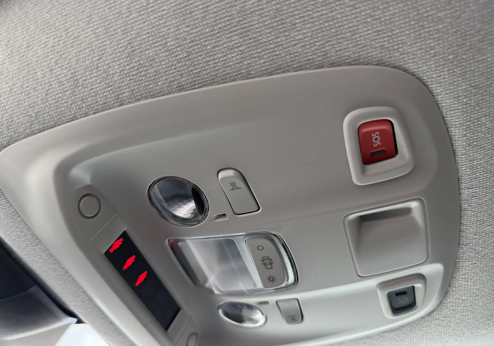 Vue en gros plan du plafonnier intérieur gris avec bouton SOS rouge et commandes d'éclairage du Citroën Jumpy noir.