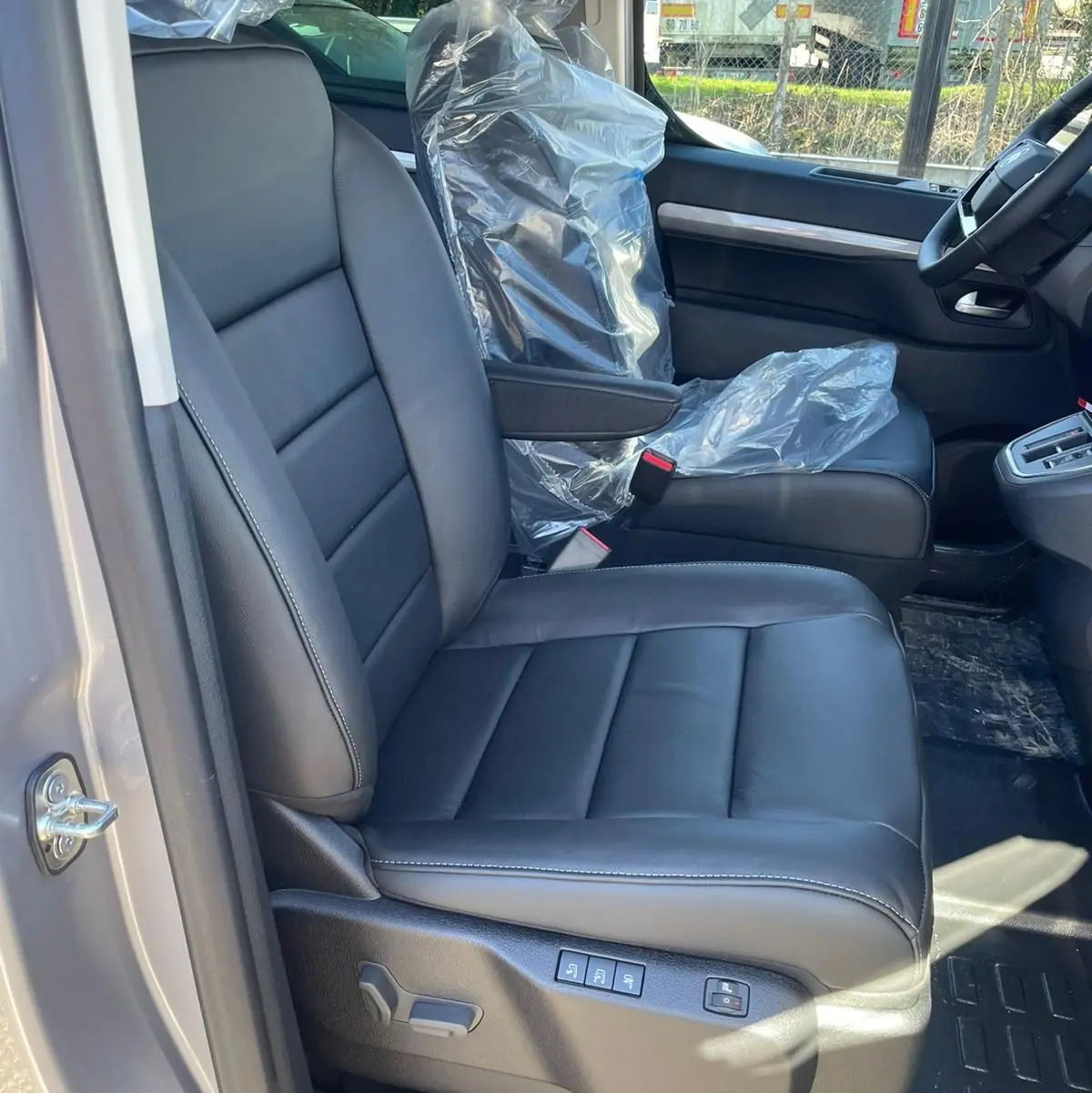 Vue intérieure côté conducteur du Citroën Jumpy Cabine Approfondie 2026, siège en cuir noir avec commandes électriques visibles.