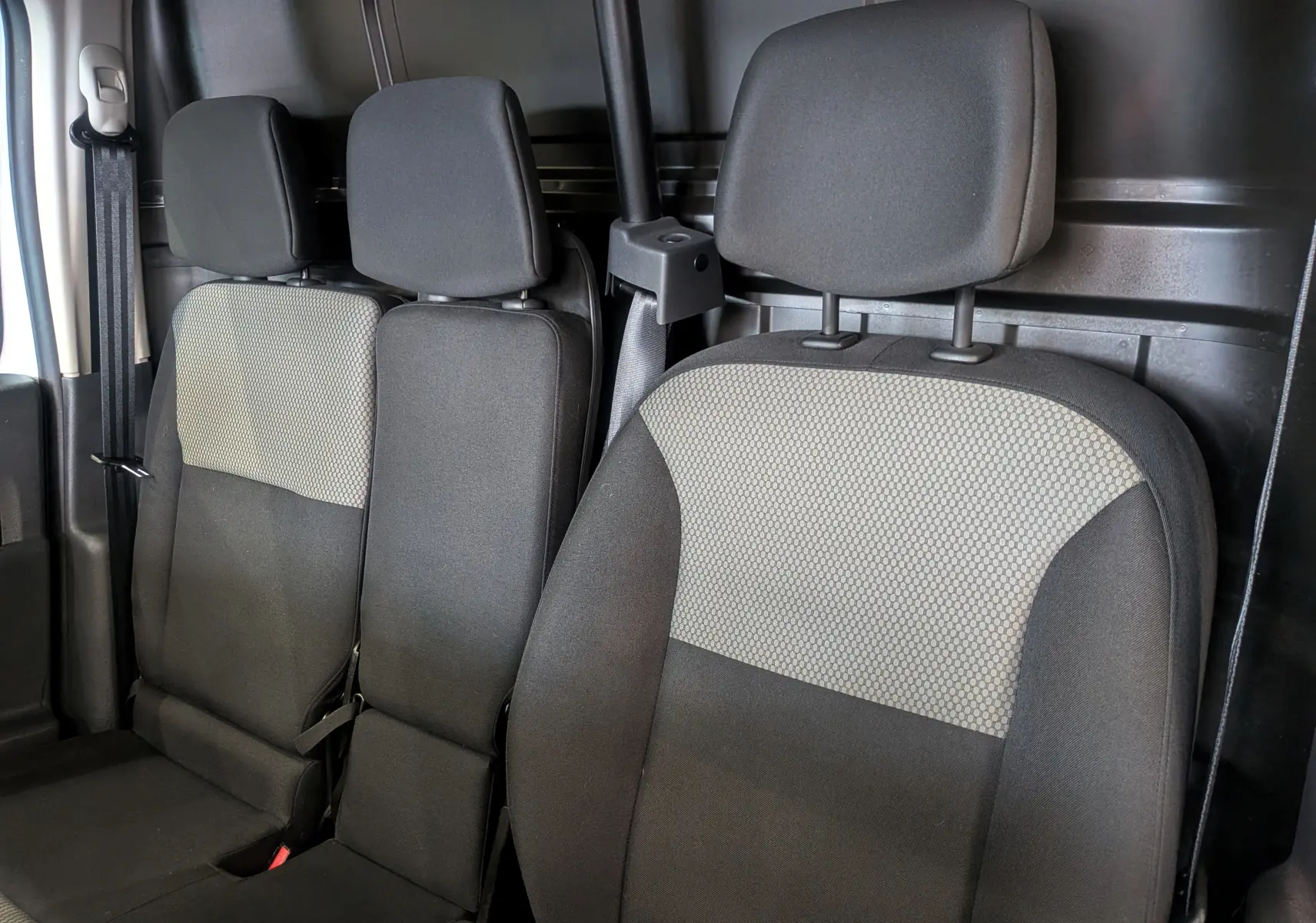 Vue intérieure des sièges avant en tissu gris foncé et clair du Renault Kangoo Express Blanc Minéral, version Blue dCi 95 CH PRO+.