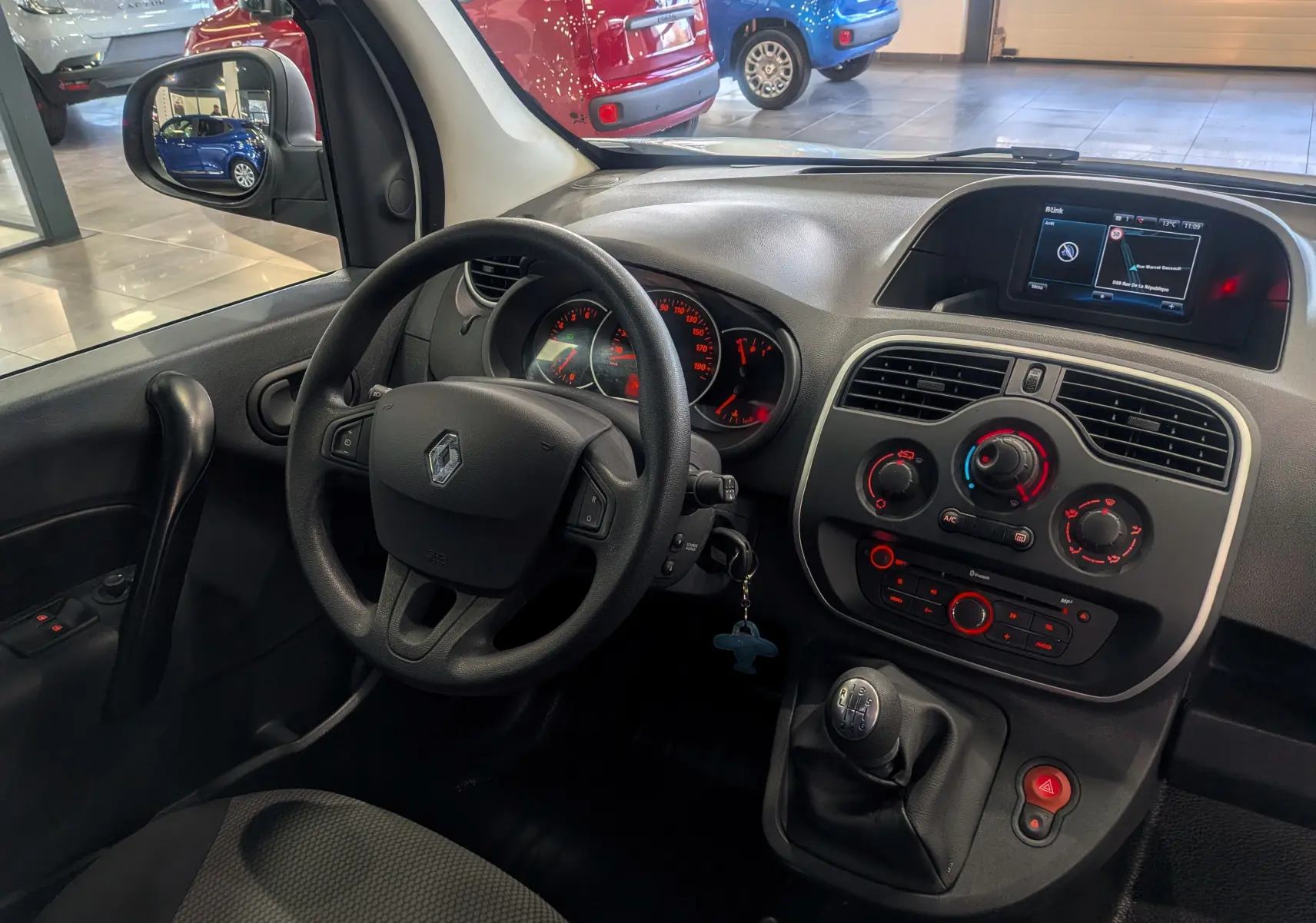 Vue intérieure côté conducteur du Renault Kangoo Express 2020 blanc, avec tableau de bord et levier de vitesses manuel visibles.