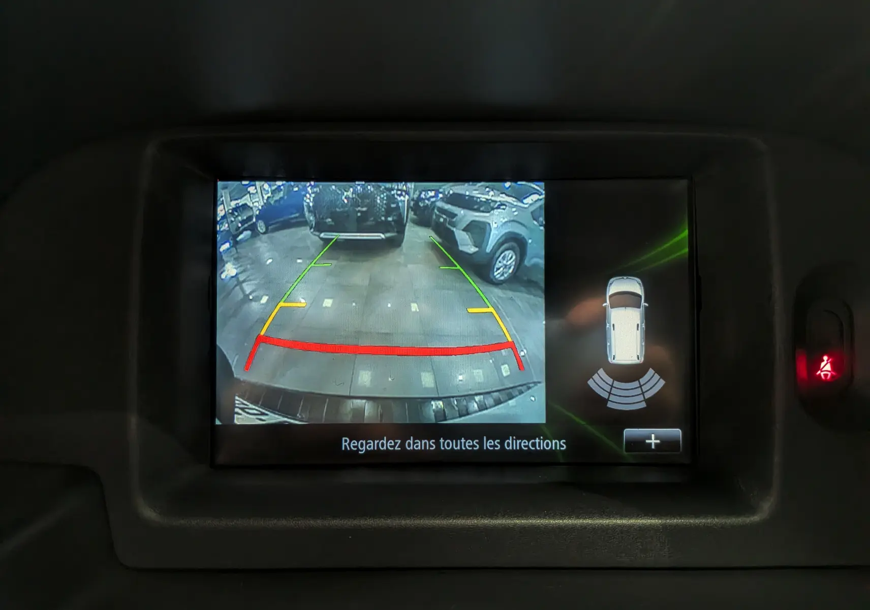 Écran de caméra de recul du Renault Kangoo Express blanc montrant l'arrière et les lignes de guidage colorées.