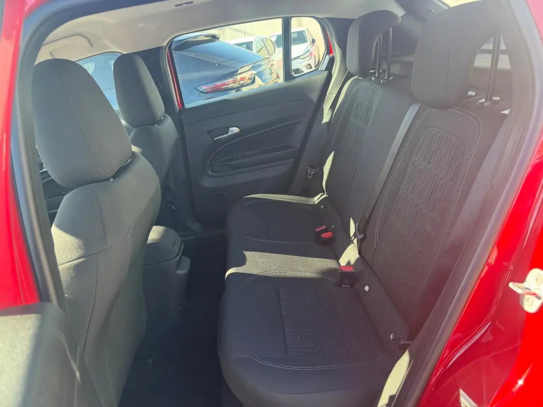 Vue intérieure côté droit des sièges arrière noirs du FIAT 600 T-Gen 3 rouge, avec détails de la porte ouverte.