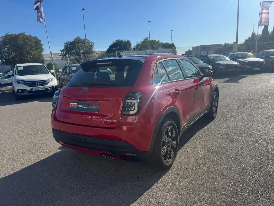 Vue 3/4 arrière droite d'une FIAT 600 T-Gen 3 rouge 2025 avec feux arrière à LED et jantes noires stylisées.
