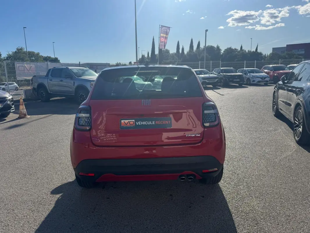 Vue arrière d'une FIAT 600 rouge 2025 avec feux arrière modernes et double sortie d'échappement visible.