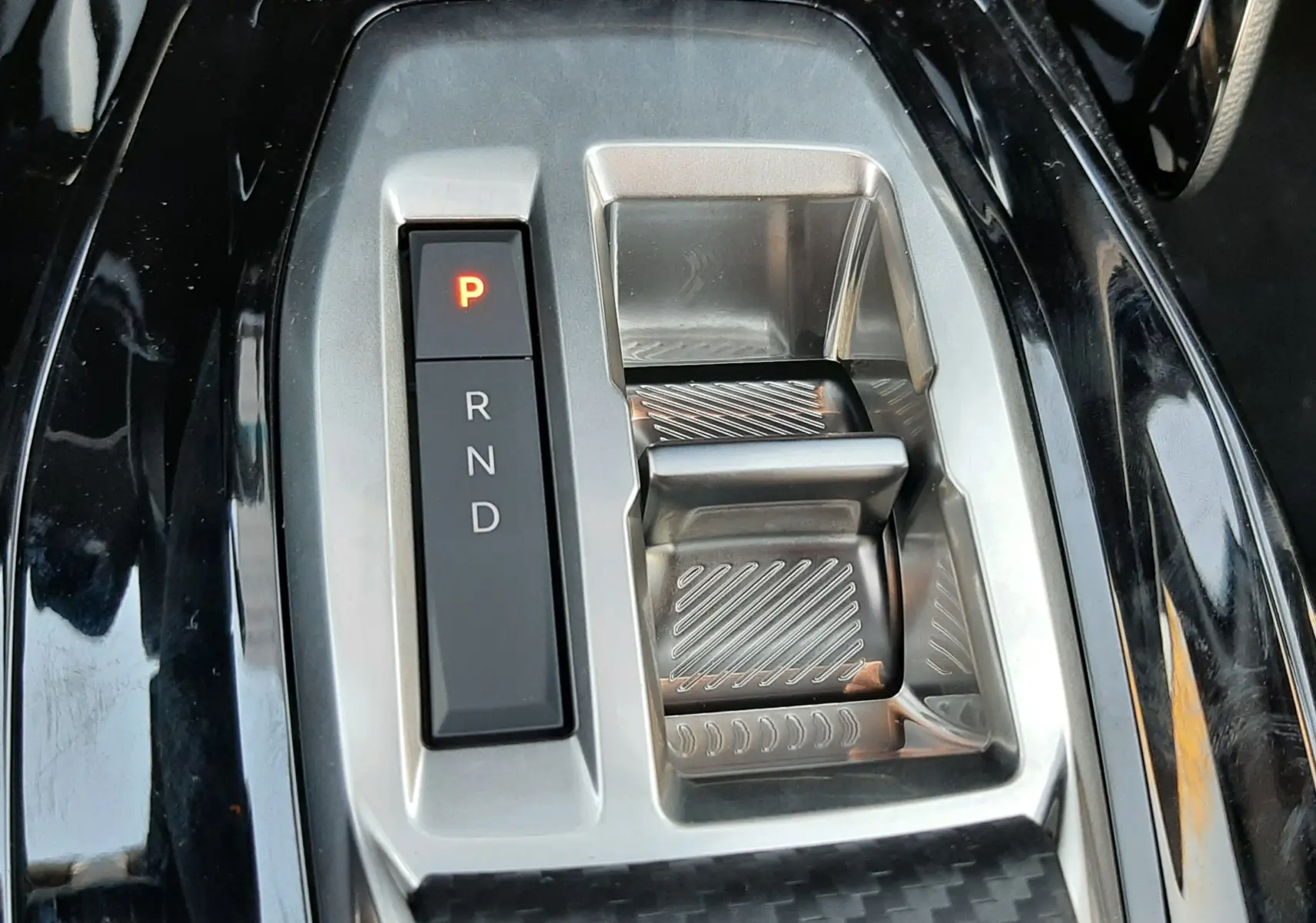 Gros plan sur la commande de boîte automatique noire et argentée du Peugeot 208 Hybrid 145ch GT 2026.