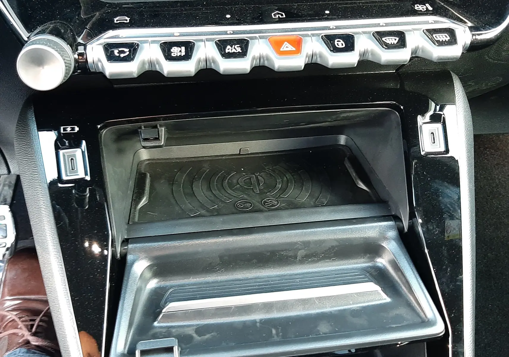 Vue rapprochée de la console centrale noire perla du Peugeot 208 Hybrid 145CH GT avec commandes et rangement ouvert.
