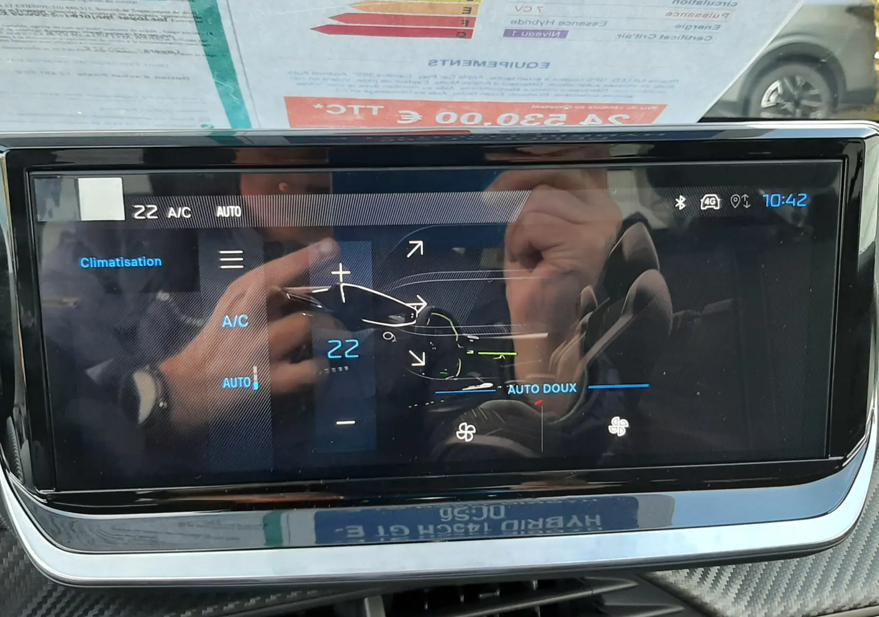 Écran tactile central du tableau de bord de la Peugeot 208 Hybrid 145ch GT, affichant la climatisation à 22°C, intérieur noir.