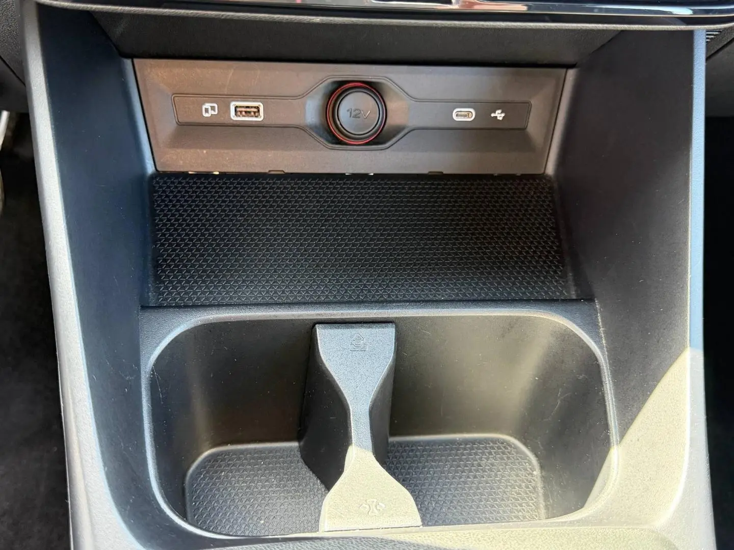 Gros plan sur la console centrale noire du MG3 1.5 Hybrid+ 2025, avec prise 12V et ports USB visibles.