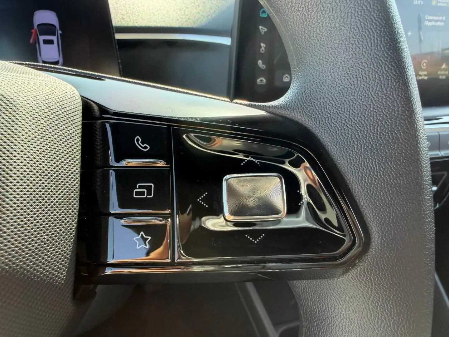 Gros plan sur les commandes noires au volant du MG3 1.5 Hybrid+ blanc, avec touches multifonctions visibles.