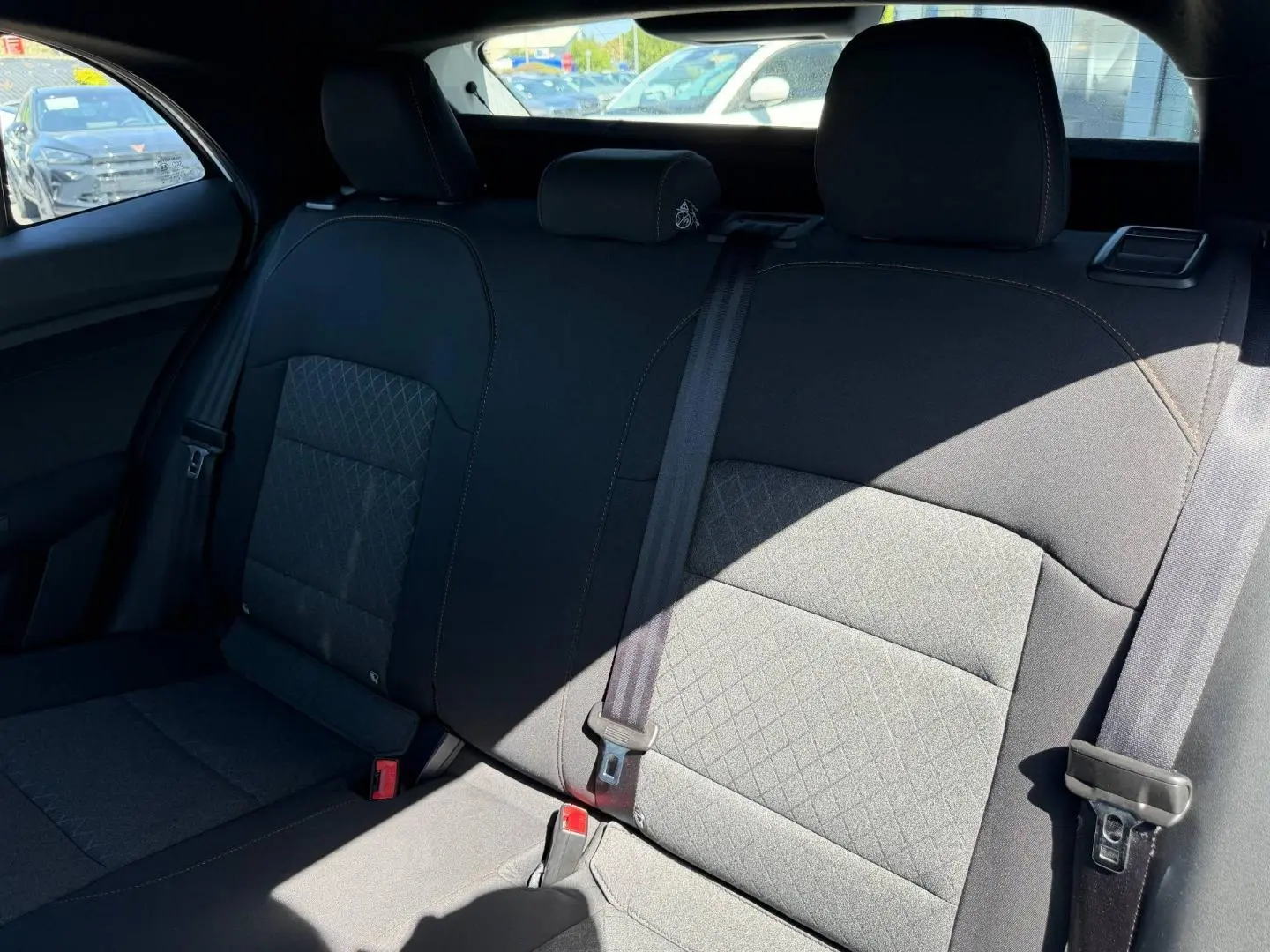 Vue intérieure de la banquette arrière en tissu noir du MG3 1.5 Hybrid+ 195ch Comfort, avec ceintures de sécurité visibles.