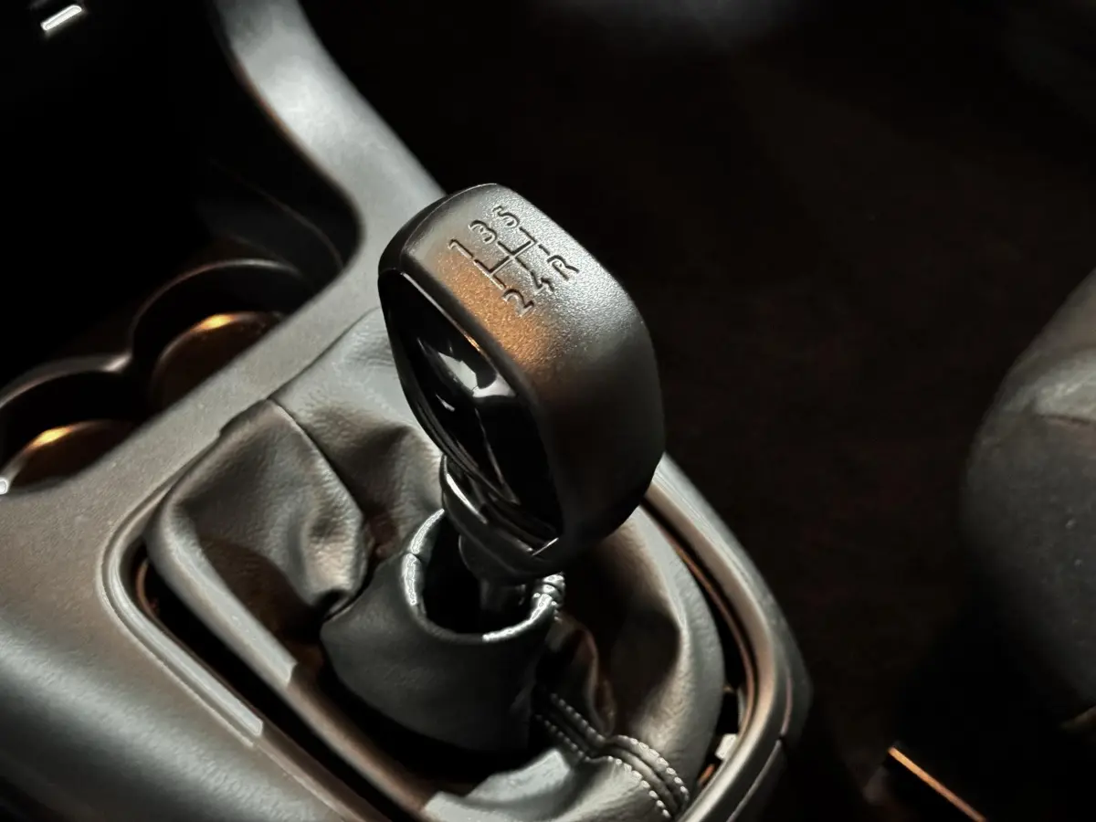Le levier de vitesses manuel noir de la Citroën C3 PureTech 83 S&S BVM PRO PLUS en gros plan intérieur.