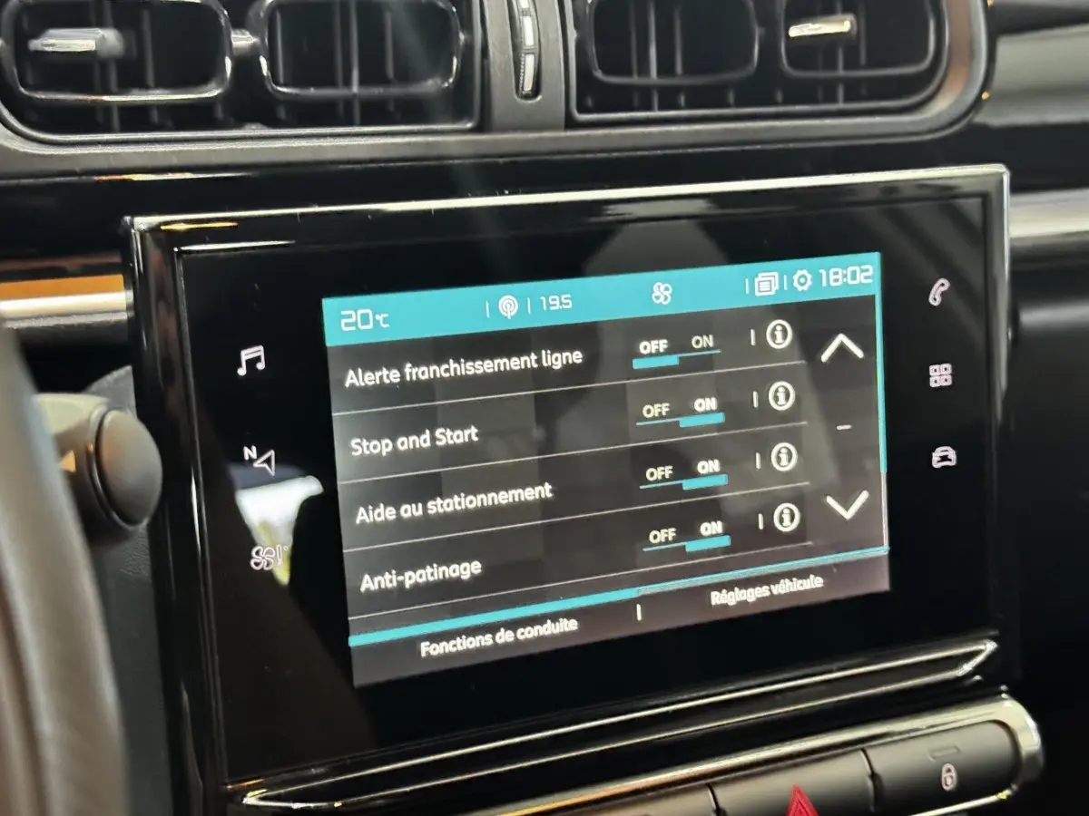 Écran tactile central de la Citroën C3 blanc, affichant les réglages d’aides à la conduite en intérieur.