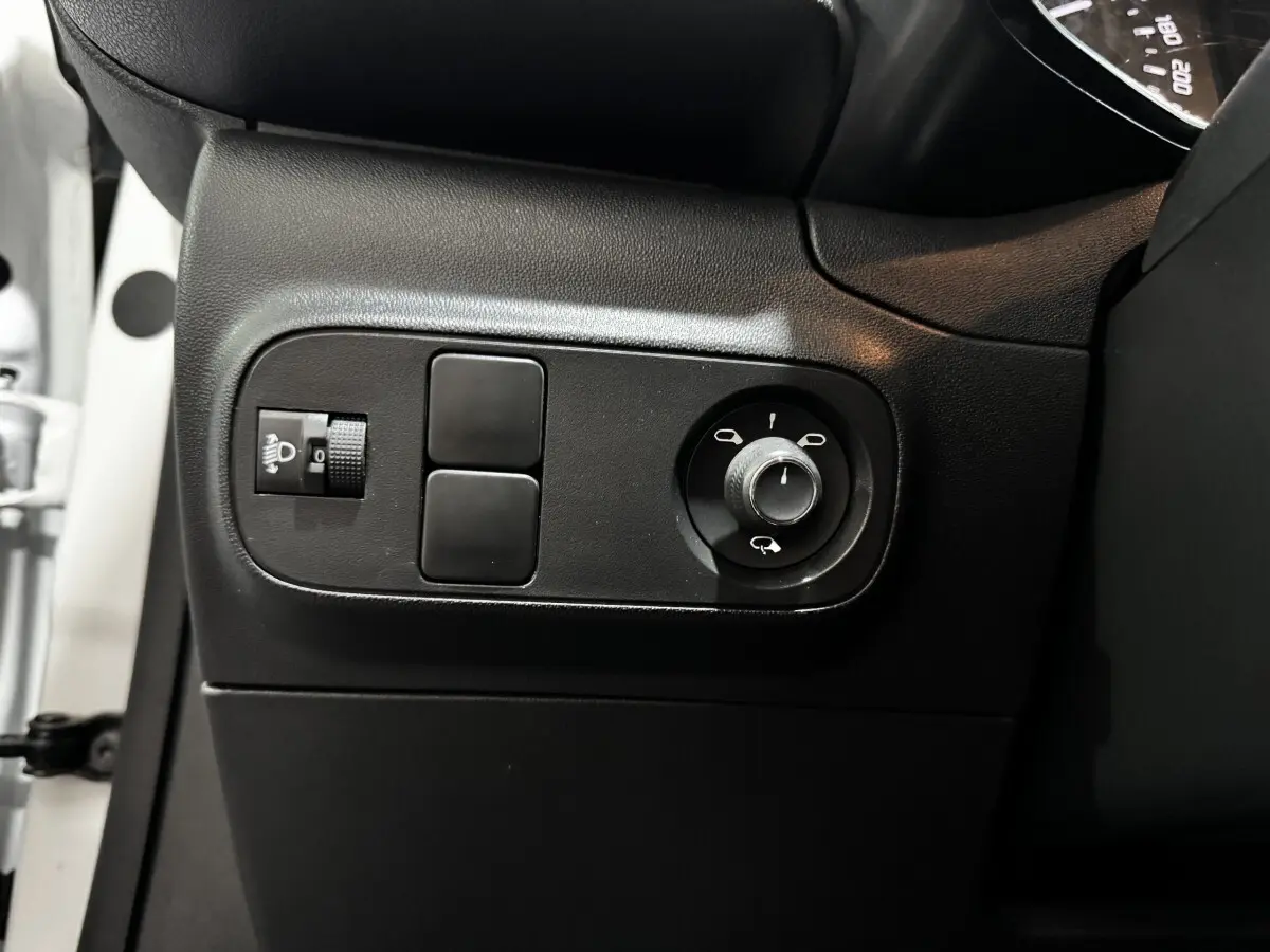 Vue rapprochée du panneau de réglage des rétroviseurs et des phares côté conducteur d'une Citroën C3 blanche 2024.