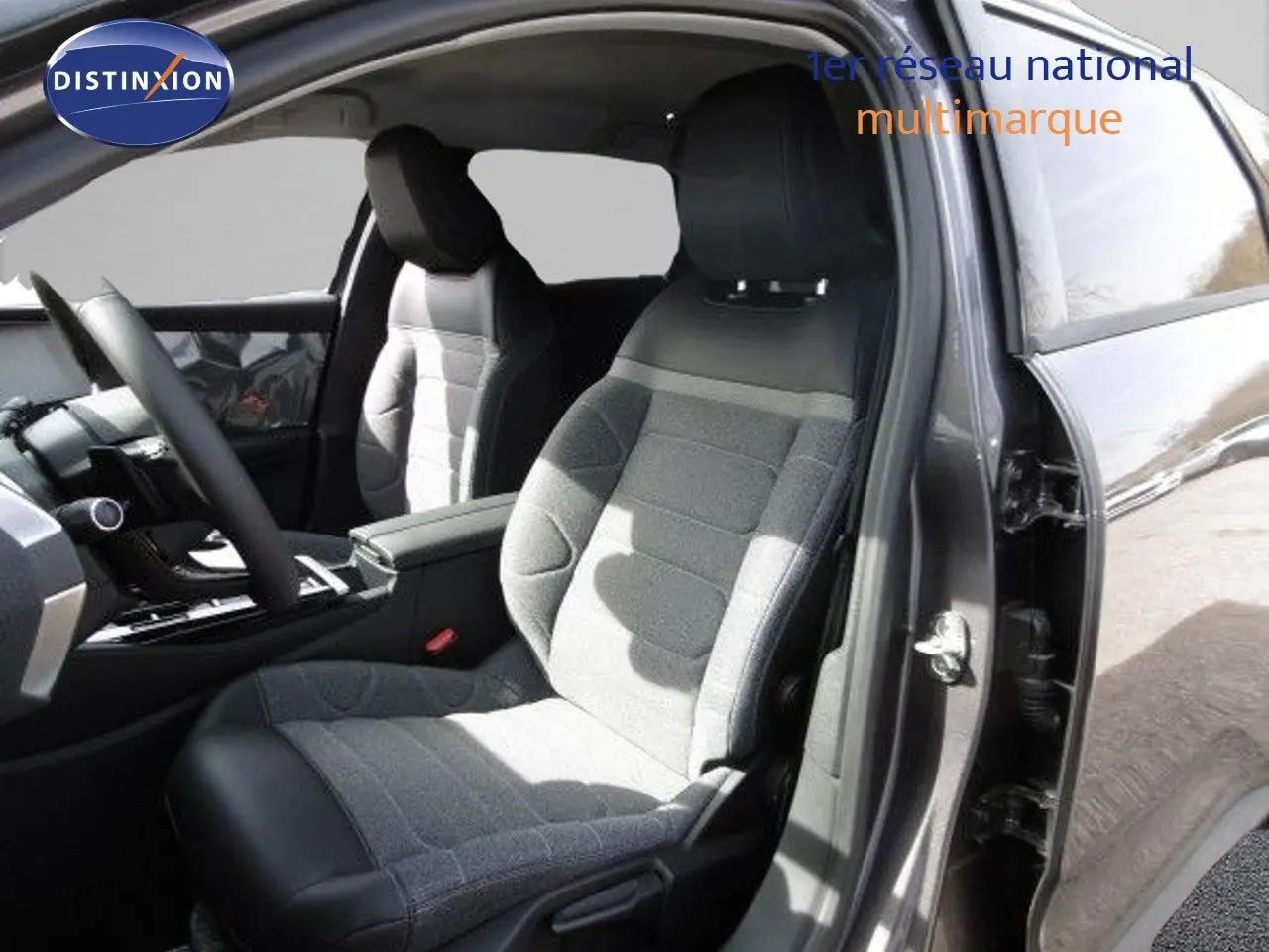 Intérieur du Citroën C5 X 2023 en gris platinium, vue côté conducteur avec sièges tissu et cuir noir mêlés.