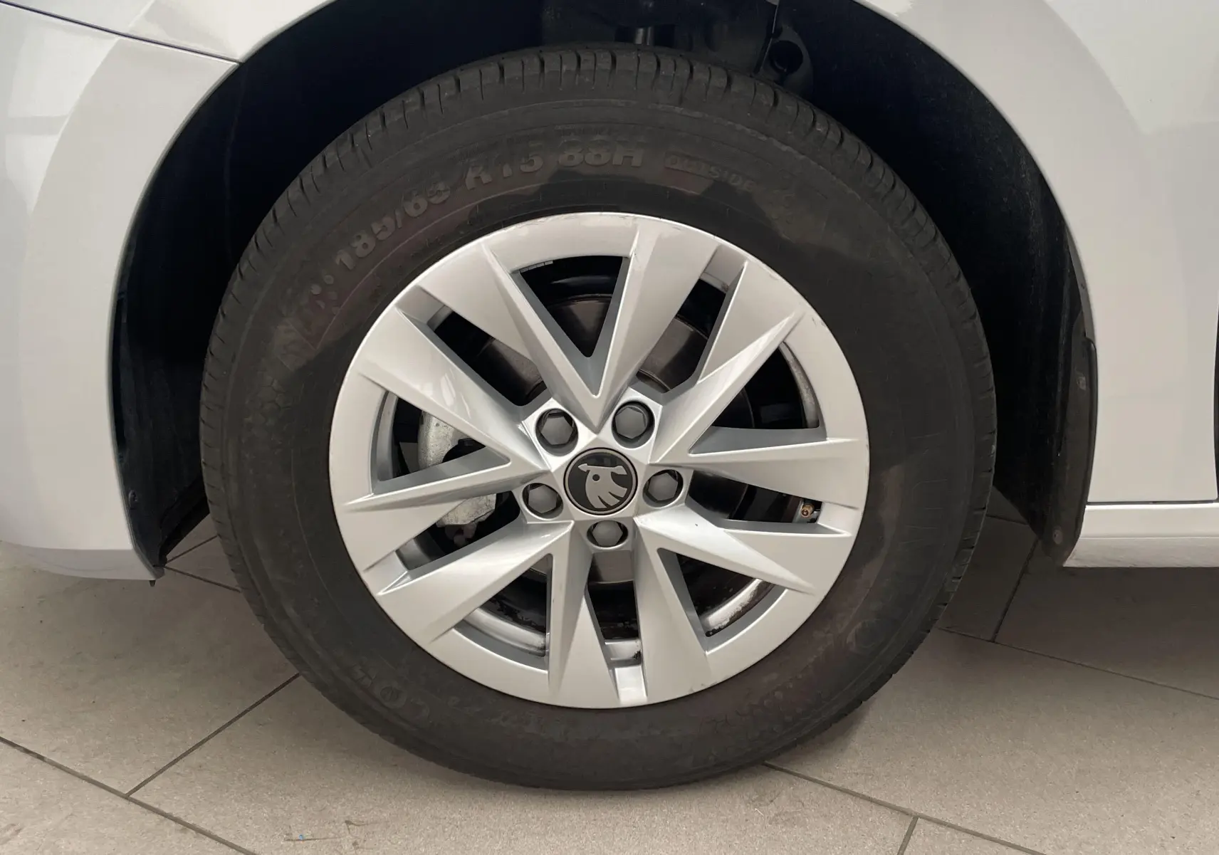 Gros plan sur la roue avant gauche d'une Skoda Fabia gris argent 2025 avec jante en alliage au design étoilé.