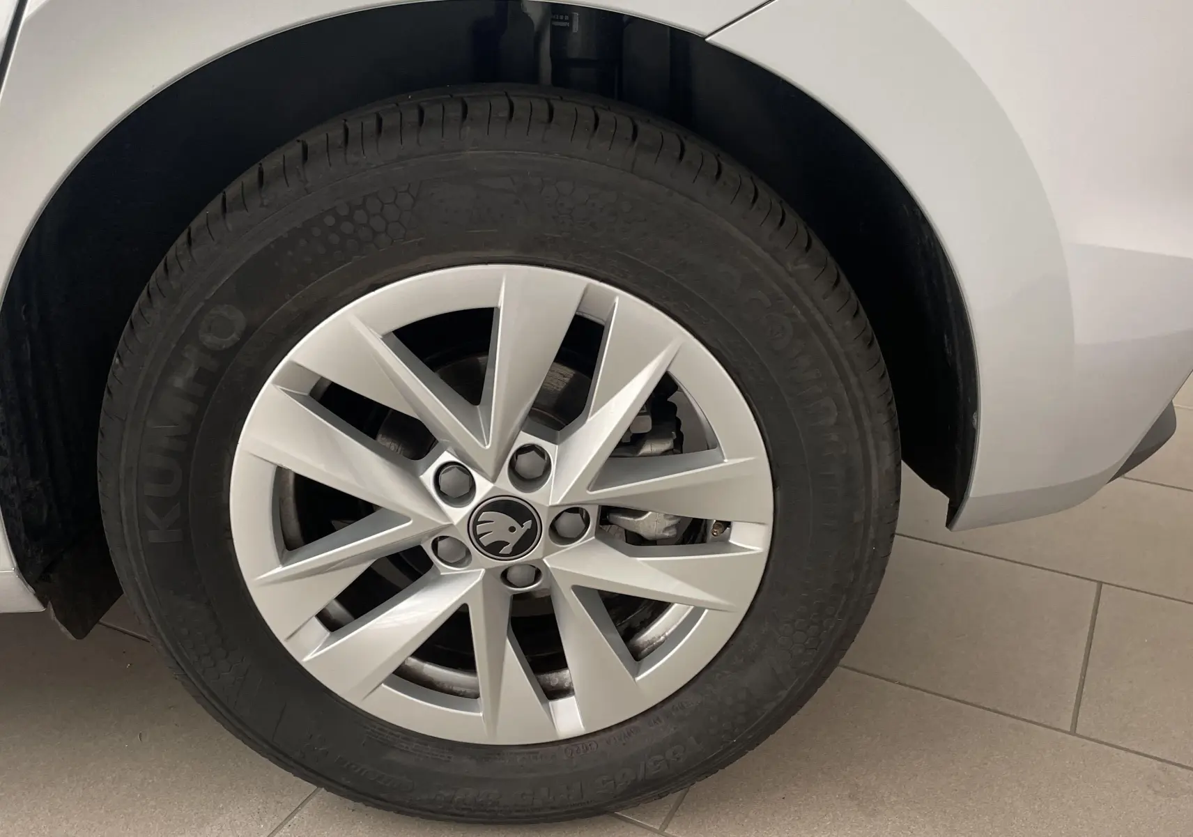 Gros plan sur la roue arrière droite gris argent d'une Skoda Fabia 2025 avec jante en alliage et logo central noir.