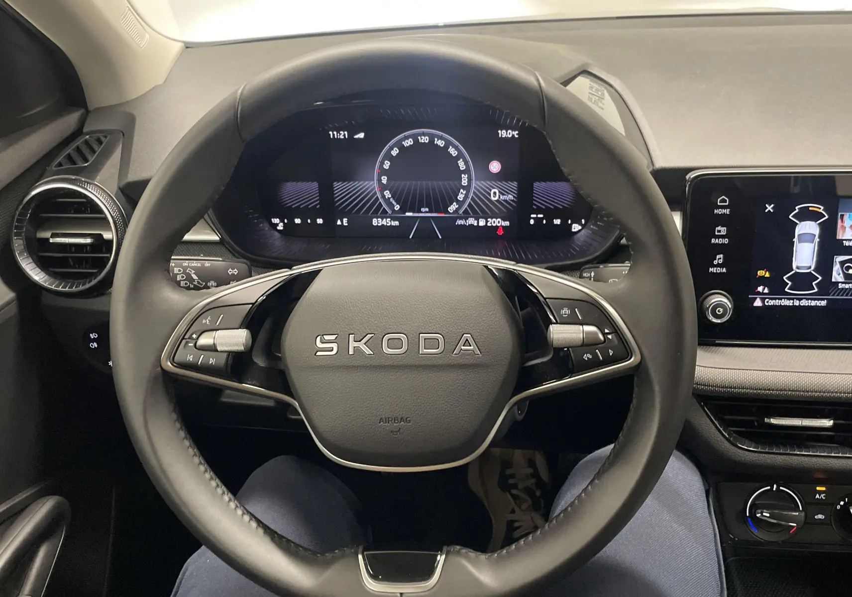 Vue intérieure centrée sur le volant SKODA Fabia 2025, tableau de bord digital et écran tactile multifonction.