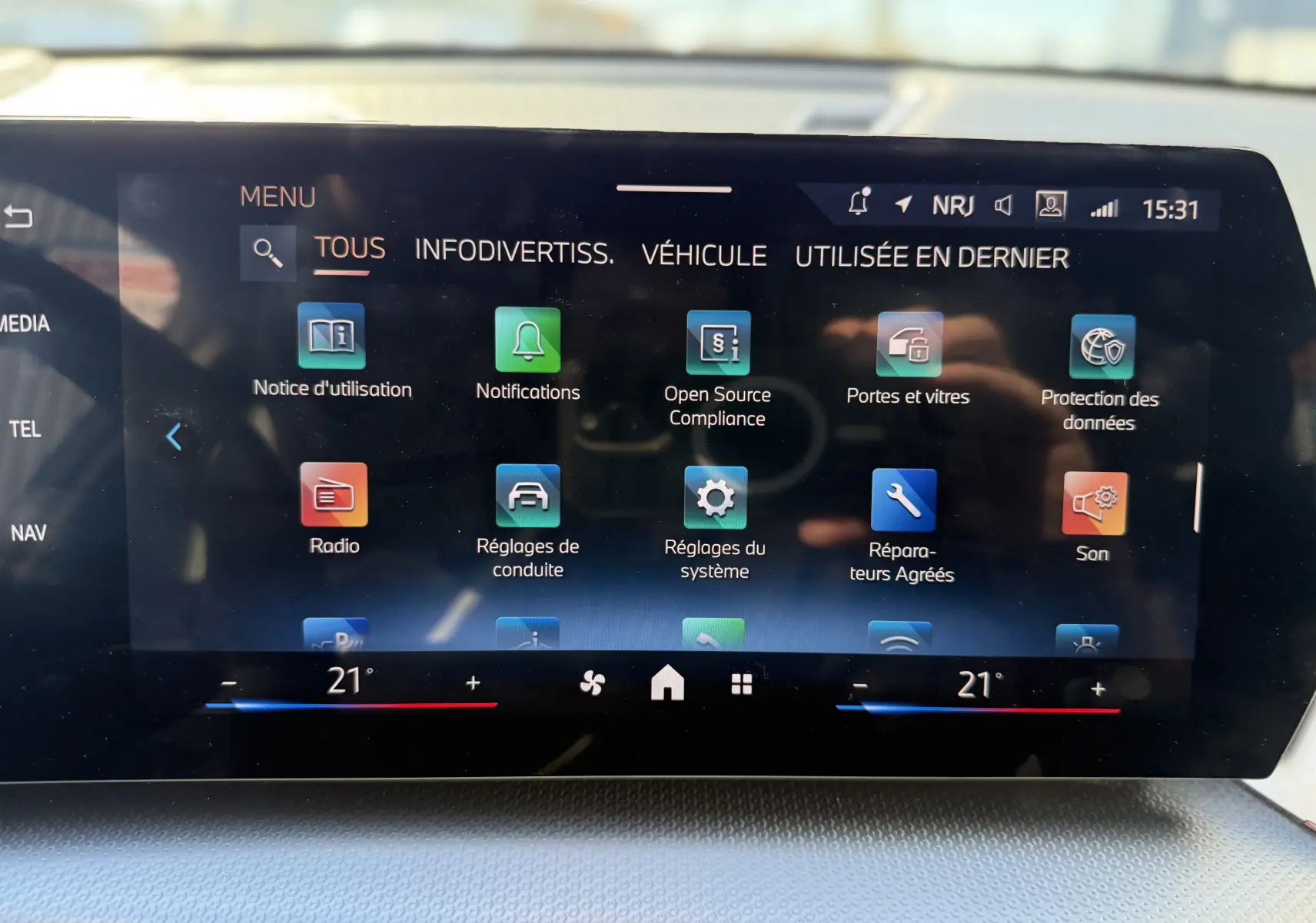 Écran tactile central du BMW X1 2025 affichant le menu des réglages avec interface moderne et température à 21°C.