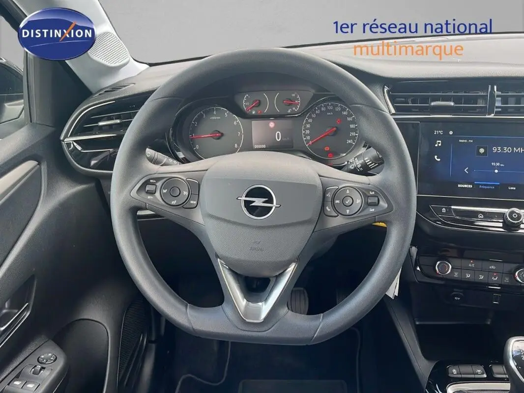 Vue intérieure centrée sur le volant multifonctions d'une Opel Corsa gris 2025 avec tableau de bord et écran tactile visibles.